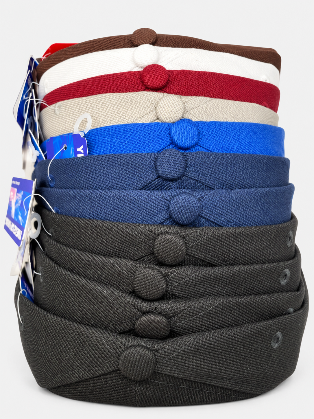 Stack of plain baseball hats in several colors