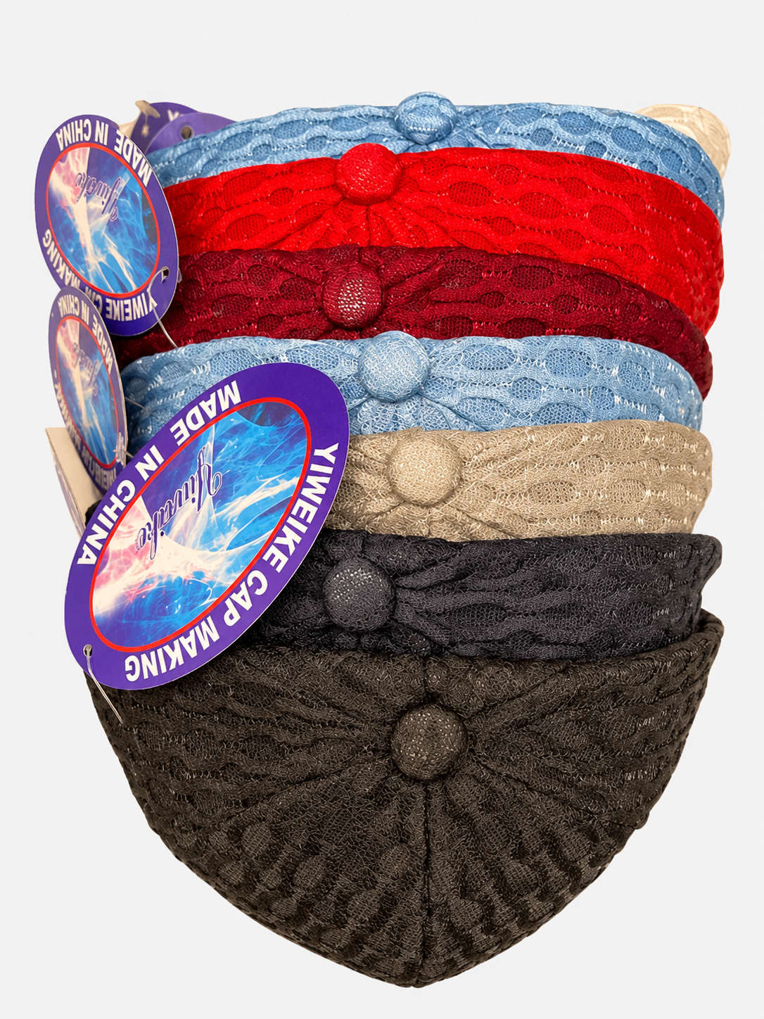 Stack of patterned netted baseball caps in several colors on a light gray background