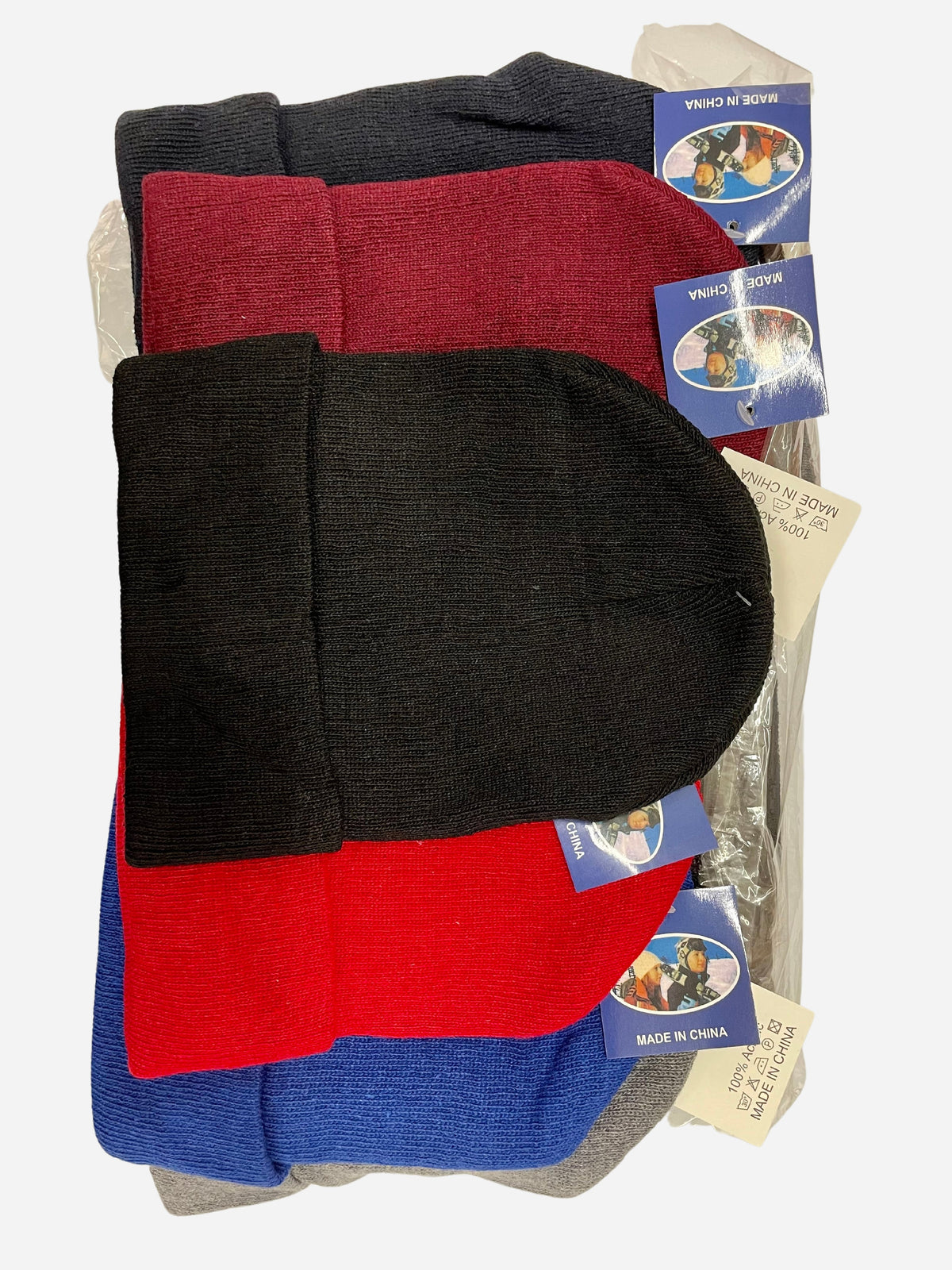 Stack of plain knit beanies in black, burgundy, gray, red and blue